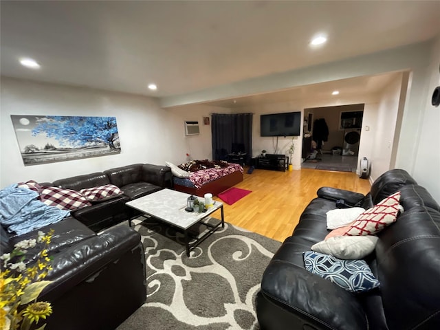 living room featuring wood-type flooring and a wall unit AC