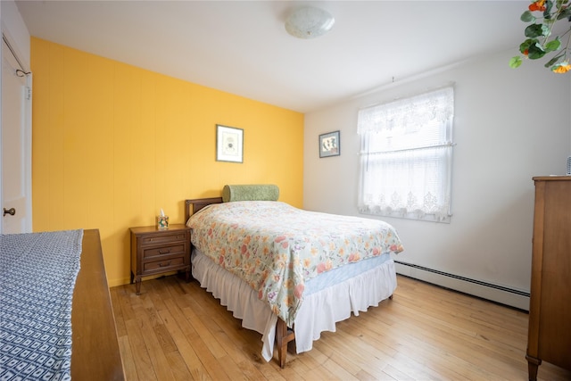 bedroom with light wood-type flooring and a baseboard radiator