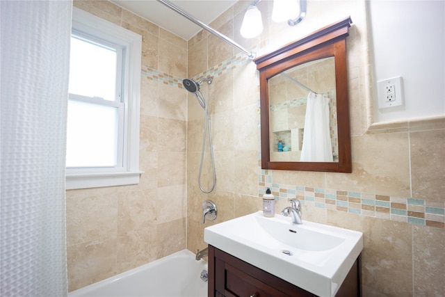 bathroom with shower / tub combo, vanity, and tile walls