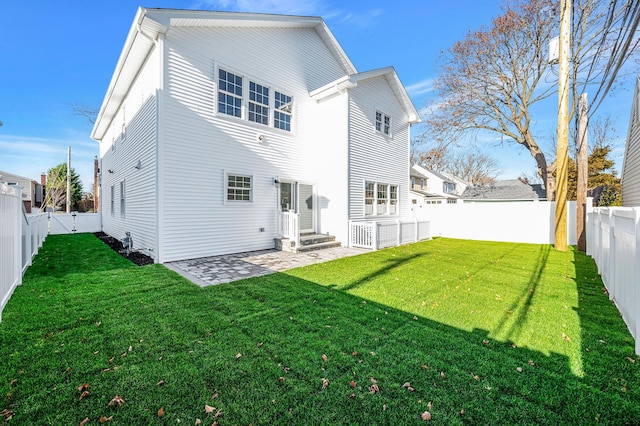 rear view of house featuring a patio and a lawn