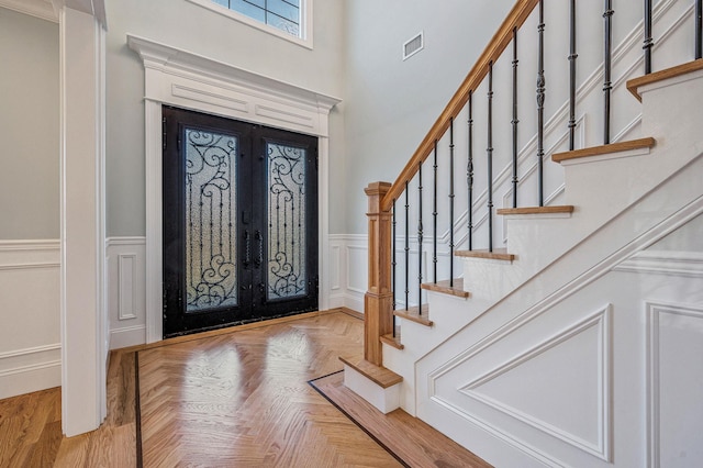 entryway with light parquet flooring and french doors