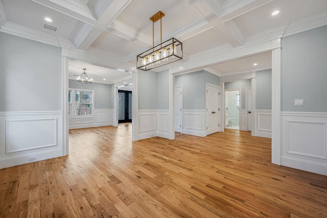 unfurnished dining area with a chandelier, beamed ceiling, and ornamental molding