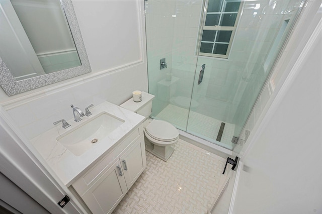 bathroom with a shower with door, vanity, and toilet