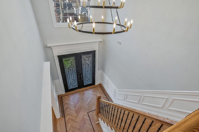 foyer entrance featuring an inviting chandelier and parquet floors