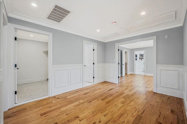 interior space featuring hardwood / wood-style flooring, a closet, a spacious closet, and ornamental molding