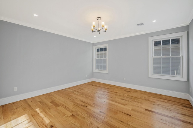 unfurnished room with light hardwood / wood-style flooring, an inviting chandelier, and crown molding