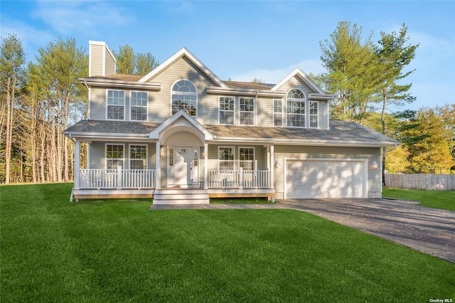 view of front of house with covered porch, a garage, and a front yard