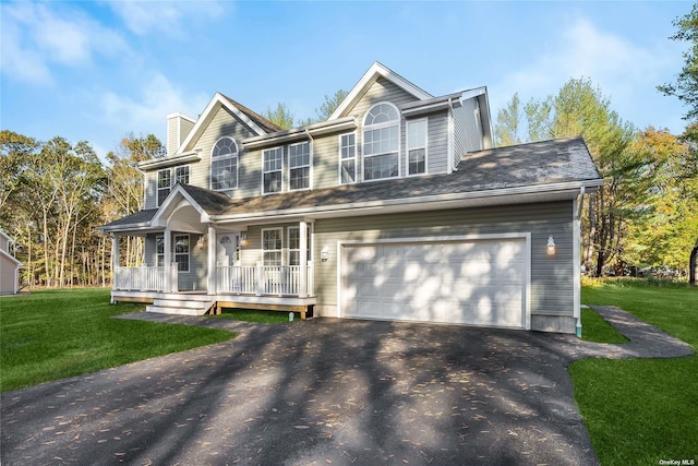 view of front of home featuring covered porch, a garage, and a front yard