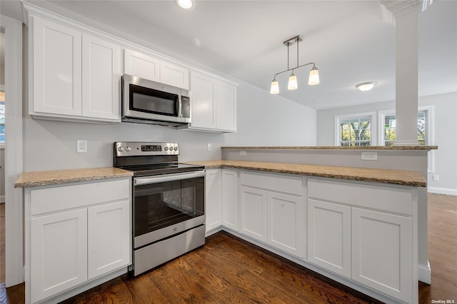 kitchen with dark wood-type flooring, decorative light fixtures, a peninsula, stainless steel appliances, and white cabinetry