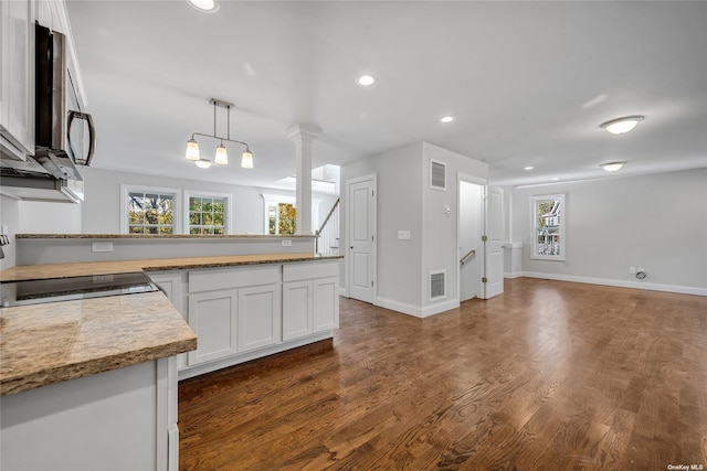 kitchen featuring a healthy amount of sunlight, white cabinetry, dark hardwood / wood-style flooring, and hanging light fixtures