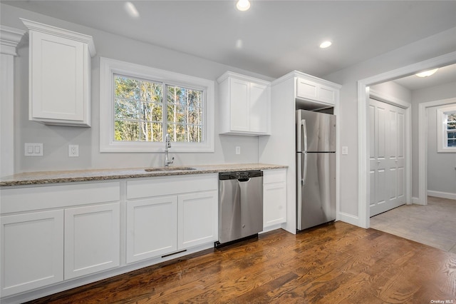 kitchen featuring a sink, dark wood-type flooring, white cabinets, and stainless steel appliances