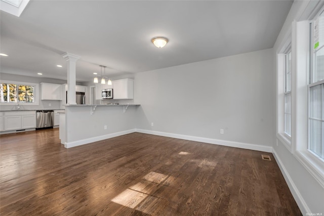 unfurnished living room featuring sink and dark hardwood / wood-style floors