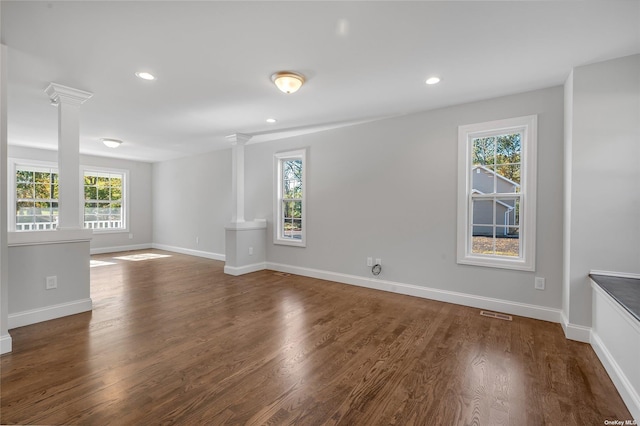 spare room featuring wood finished floors, visible vents, baseboards, decorative columns, and recessed lighting