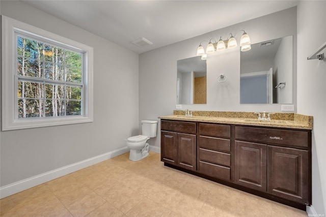 bathroom featuring visible vents, toilet, baseboards, and a sink