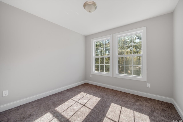 spare room featuring baseboards and carpet floors