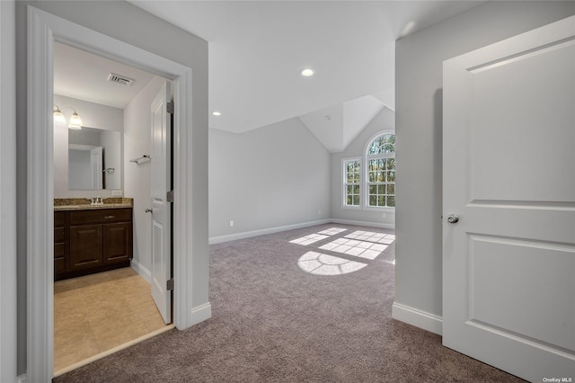 unfurnished bedroom with baseboards, lofted ceiling, recessed lighting, a sink, and light carpet