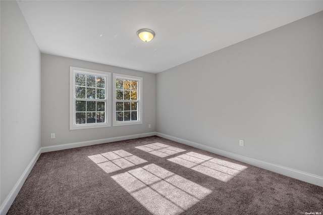 carpeted empty room with baseboards