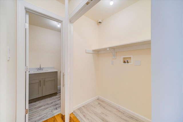 laundry area featuring hookup for a washing machine, light hardwood / wood-style floors, and sink