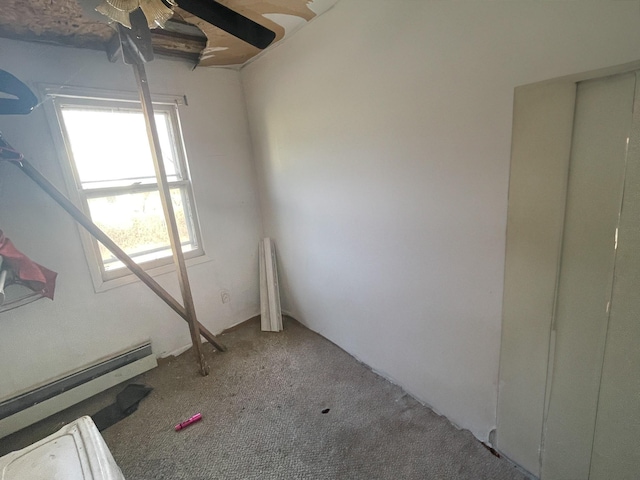 unfurnished room featuring carpet and baseboard heating