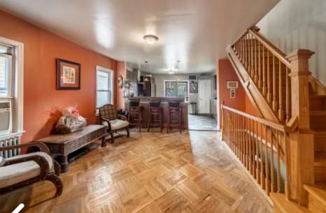 sitting room with a wealth of natural light, light parquet floors, and indoor bar