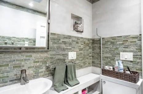 bathroom with tasteful backsplash and sink