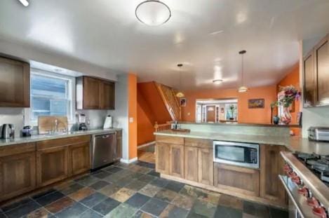 kitchen with sink, kitchen peninsula, hanging light fixtures, and stainless steel appliances