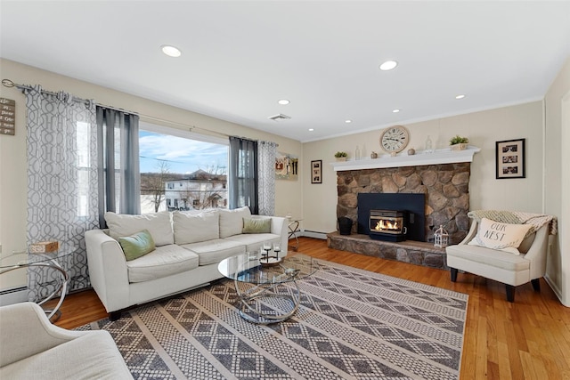 living room with a baseboard heating unit and hardwood / wood-style floors