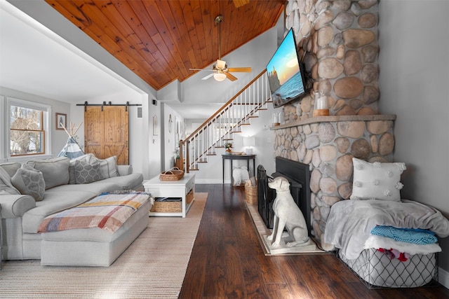 living room with hardwood / wood-style floors, a fireplace, vaulted ceiling, wooden ceiling, and a barn door