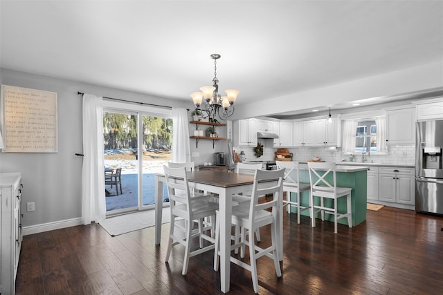 dining area with dark hardwood / wood-style floors and a chandelier