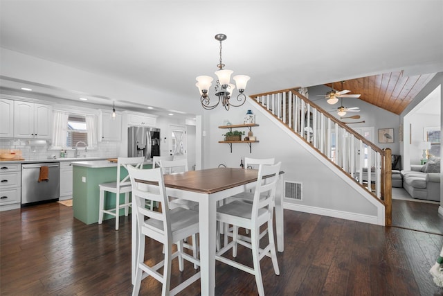 dining space with vaulted ceiling, sink, ceiling fan with notable chandelier, and dark hardwood / wood-style flooring