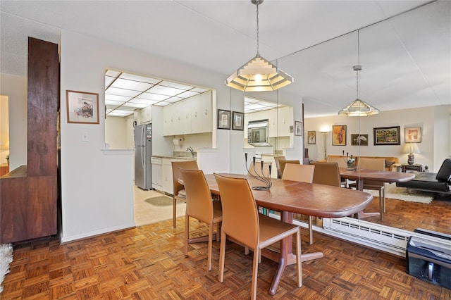 dining space featuring sink and parquet floors