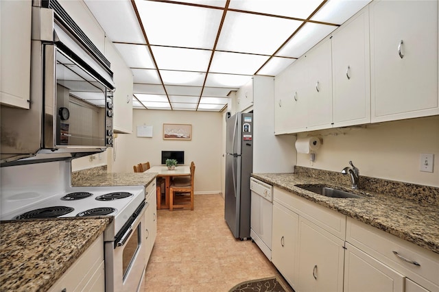 kitchen with sink, white cabinets, appliances with stainless steel finishes, and dark stone counters