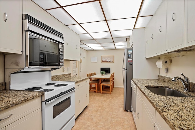 kitchen with light stone counters, sink, white cabinetry, and stainless steel appliances