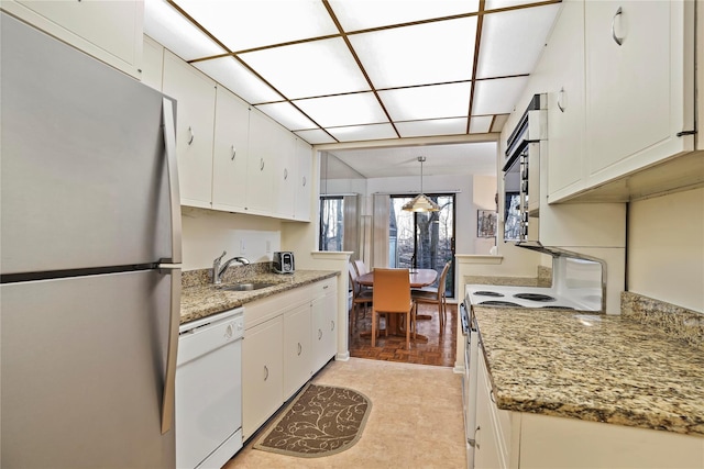 kitchen with light stone countertops, white cabinetry, sink, pendant lighting, and stainless steel appliances