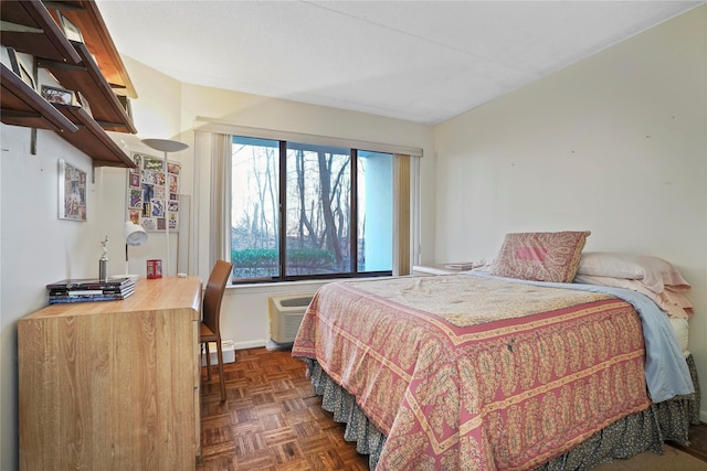 bedroom with a wall mounted air conditioner and dark parquet floors