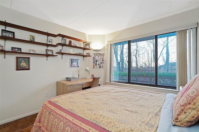 bedroom featuring dark parquet floors, a textured ceiling, and multiple windows