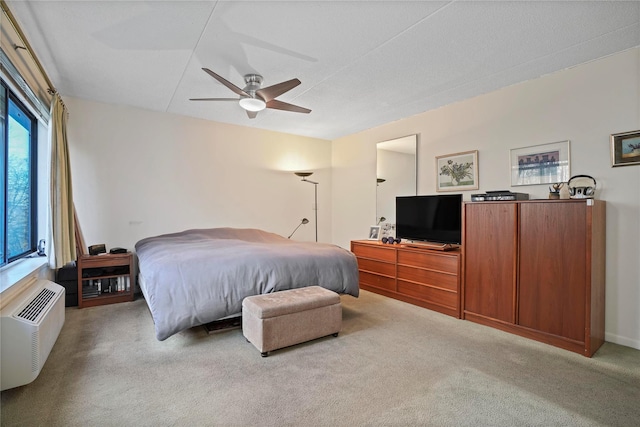 bedroom featuring ceiling fan, multiple windows, light carpet, and a wall mounted air conditioner