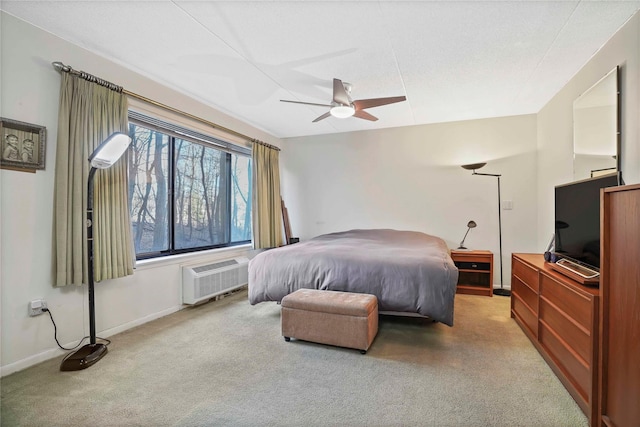 carpeted bedroom with a wall unit AC and ceiling fan