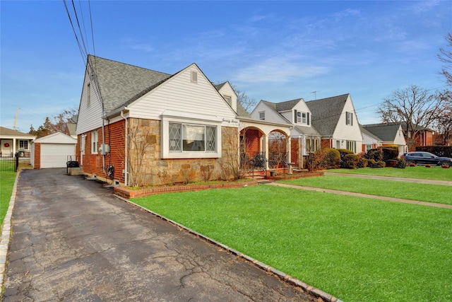 view of front of property with a garage, a front lawn, and an outdoor structure