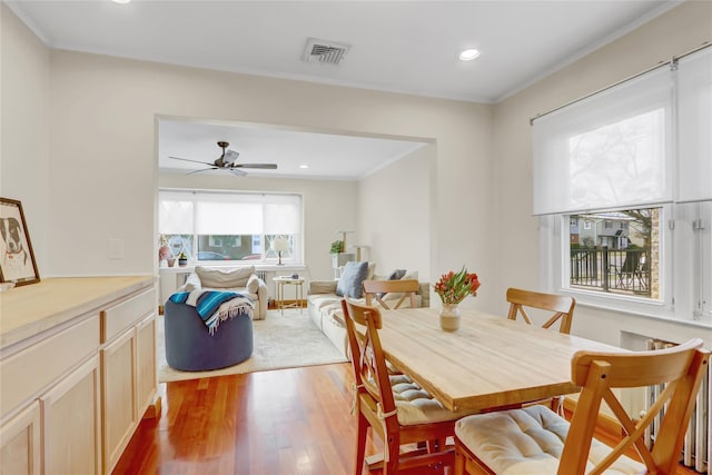 dining room with ceiling fan, wood-type flooring, and crown molding