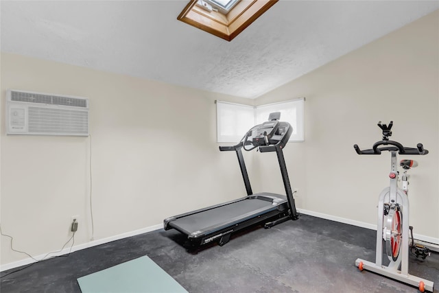 workout room featuring an AC wall unit, vaulted ceiling with skylight, and a textured ceiling