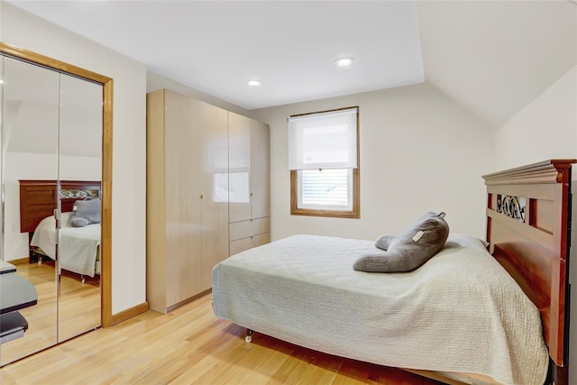 bedroom with vaulted ceiling and light wood-type flooring