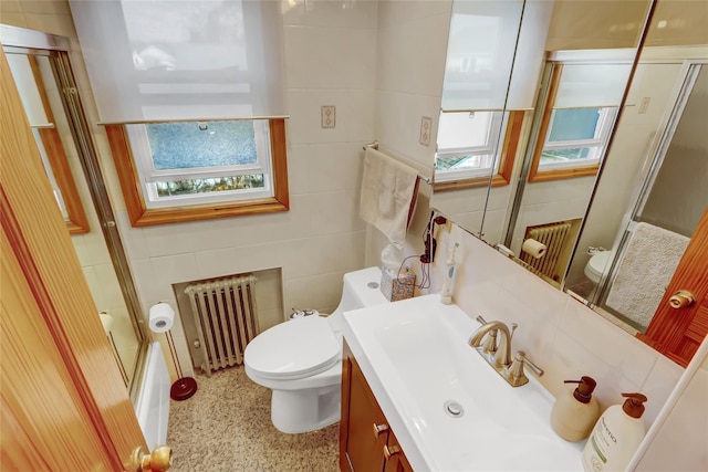 full bathroom with radiator, vanity, tile walls, and toilet