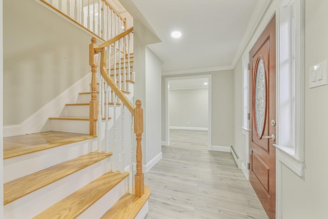 foyer featuring a baseboard radiator, ornamental molding, and light hardwood / wood-style floors