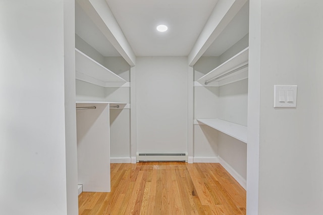 spacious closet with light hardwood / wood-style flooring and a baseboard radiator