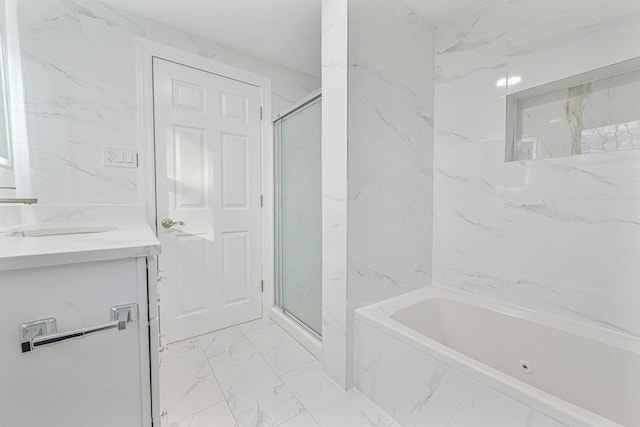 bathroom featuring plus walk in shower, vanity, and tile walls