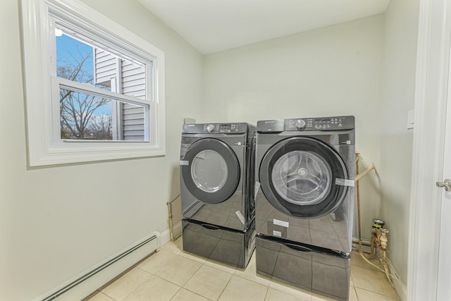 laundry room with baseboard heating, washing machine and dryer, and light tile patterned floors