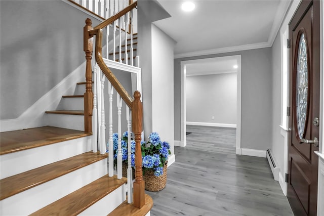 entrance foyer with ornamental molding, dark wood-type flooring, and baseboard heating