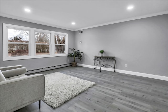 sitting room with hardwood / wood-style flooring, crown molding, and baseboard heating