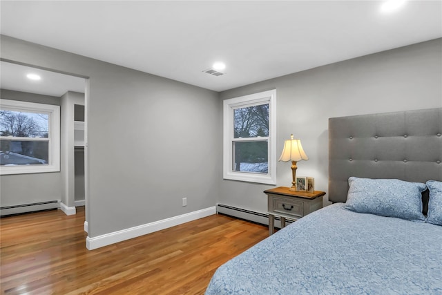 bedroom featuring wood-type flooring and baseboard heating